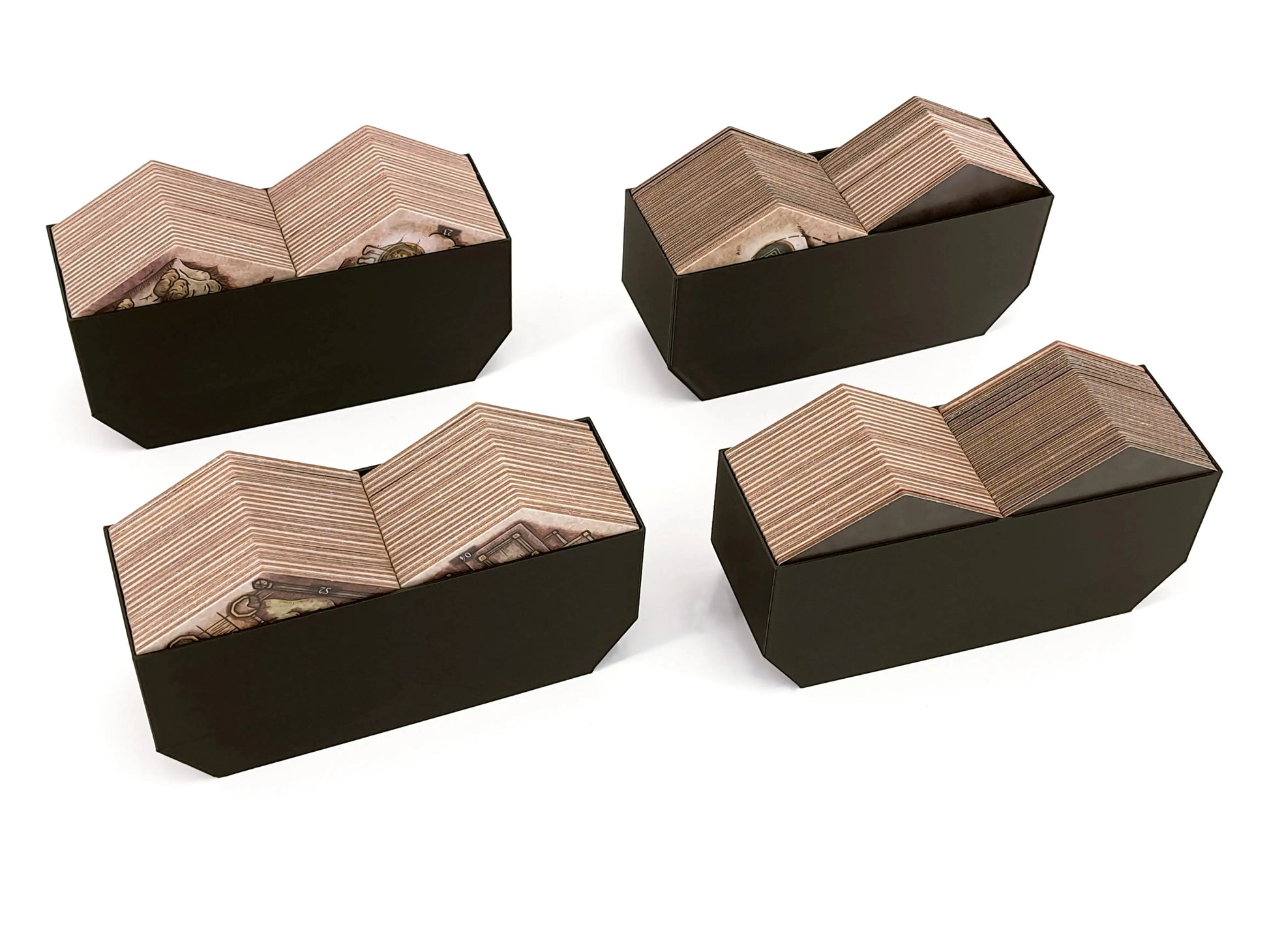 Card storage inserts for the Elden Ring board game shown as digital STL files by Tinkering Paws. The image shows four black 3D-printed card holder trays arranged on a white background, each holding large stacks of rectangular cardboard cards. The organizers feature angled compartments that keep multiple card decks upright and easy to access during gameplay. These 3D printable board game inserts are designed to fit inside the Elden Ring board game box and improve setup, sorting, and storage. Digital STL file