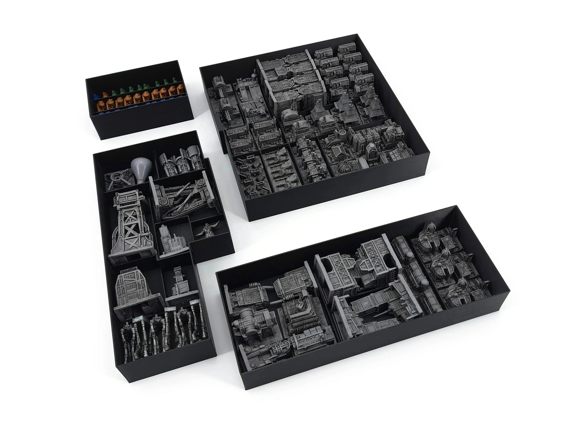 A top-down view of the Frostpunk Miniatures Expansion box filled with various grey plastic building miniatures and small blue and orange worker figures, all neatly organized into black custom-fit insert trays.